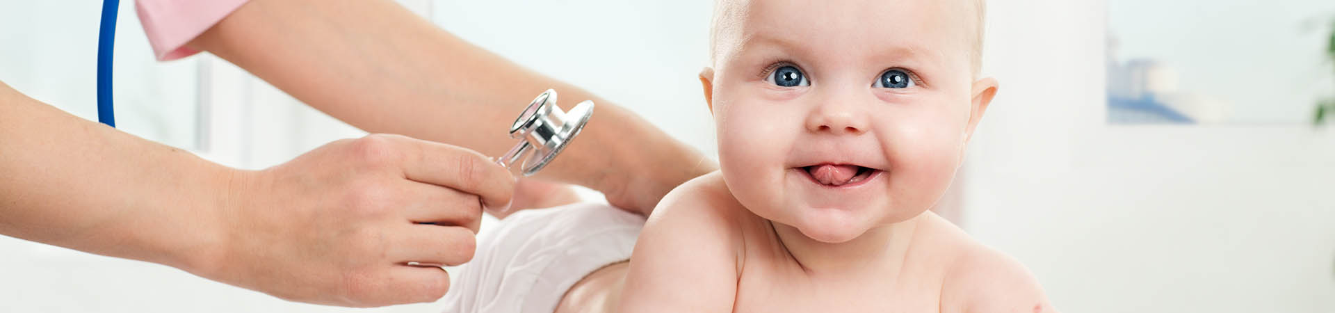 Headerbild Aus- und Weiterbildung in der Paediatrie, Ein auf dem Bauch liegendes Baby wird mit dem Stethoskop abgehört